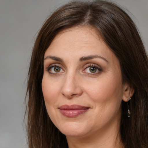 Joyful white adult female with long  brown hair and brown eyes