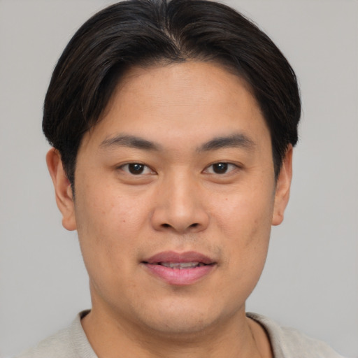 Joyful asian young-adult male with short  brown hair and brown eyes