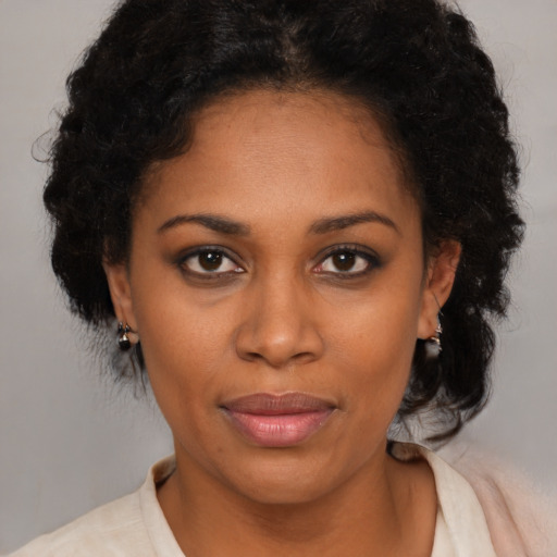 Joyful black young-adult female with short  black hair and brown eyes