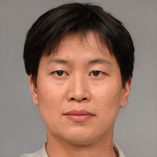Joyful asian adult male with short  brown hair and brown eyes