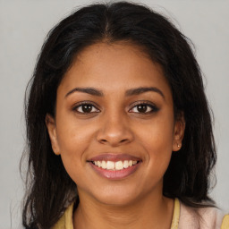 Joyful latino young-adult female with long  brown hair and brown eyes