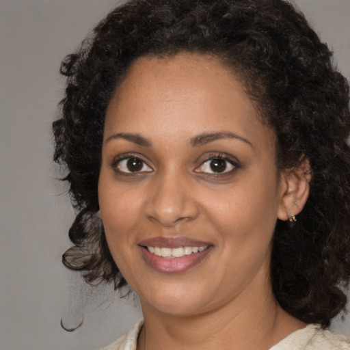 Joyful black young-adult female with medium  brown hair and brown eyes