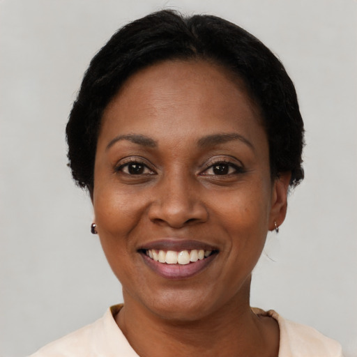 Joyful black adult female with short  black hair and brown eyes