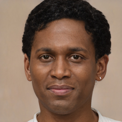Joyful black young-adult male with short  brown hair and brown eyes