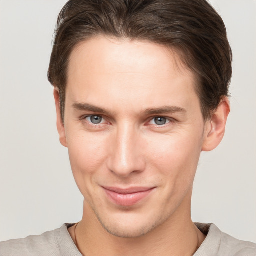 Joyful white young-adult male with short  brown hair and grey eyes