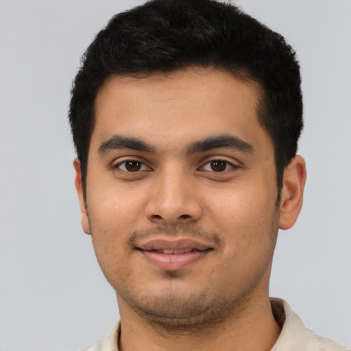 Joyful latino young-adult male with short  black hair and brown eyes