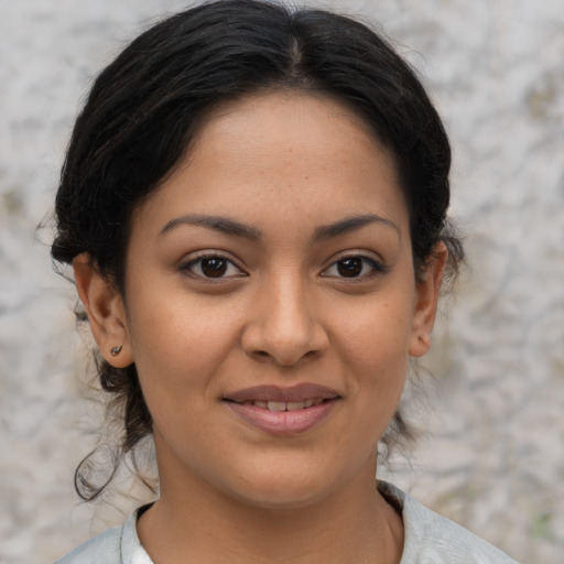 Joyful latino young-adult female with medium  brown hair and brown eyes
