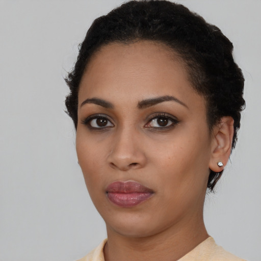 Joyful black young-adult female with short  black hair and brown eyes