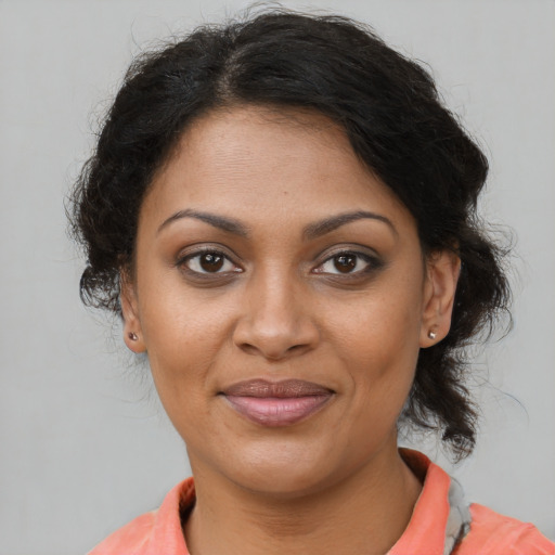 Joyful black adult female with medium  brown hair and brown eyes