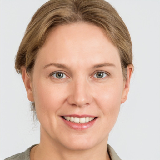 Joyful white adult female with medium  brown hair and grey eyes