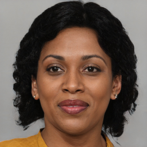 Joyful black adult female with medium  black hair and brown eyes