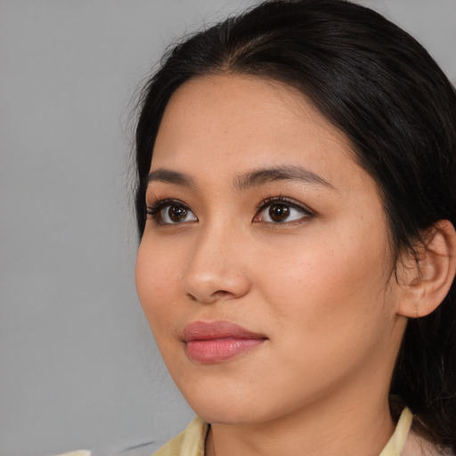 Joyful asian young-adult female with medium  brown hair and brown eyes