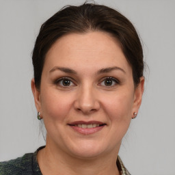 Joyful white adult female with medium  brown hair and grey eyes