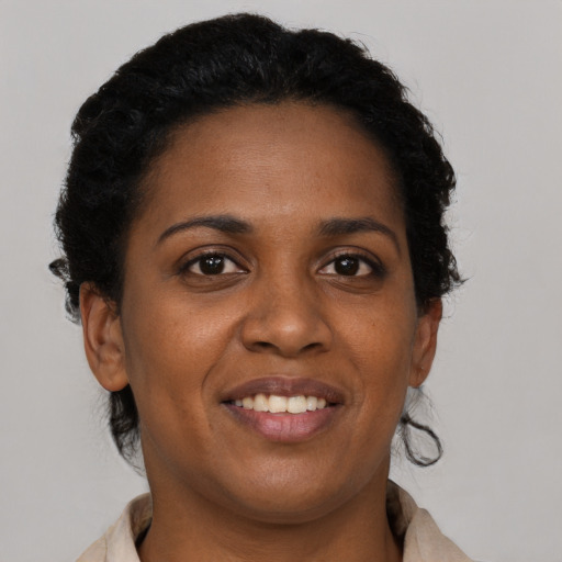 Joyful black young-adult female with short  brown hair and brown eyes