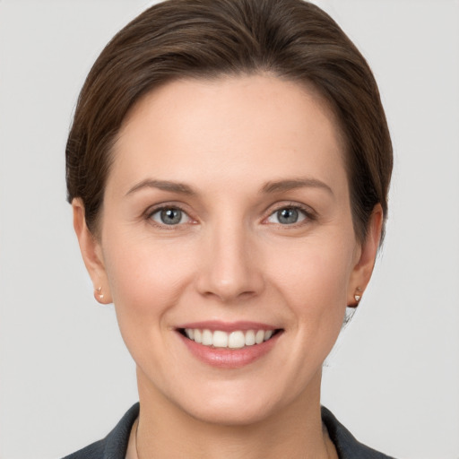 Joyful white young-adult female with short  brown hair and grey eyes