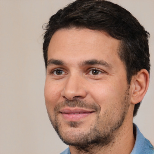 Joyful white adult male with short  black hair and brown eyes