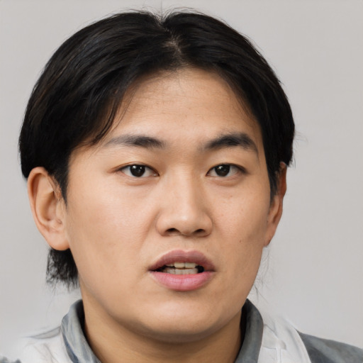 Joyful asian young-adult male with short  black hair and brown eyes