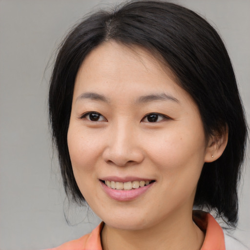 Joyful asian young-adult female with medium  brown hair and brown eyes