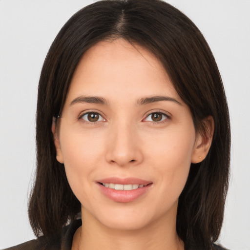 Joyful white young-adult female with long  brown hair and brown eyes