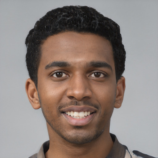 Joyful black young-adult male with short  black hair and brown eyes