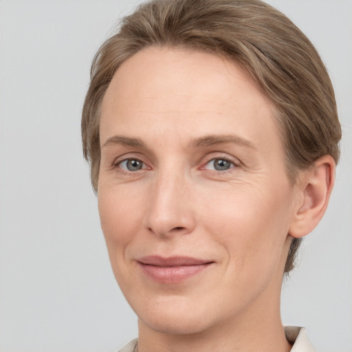 Joyful white adult female with short  brown hair and grey eyes