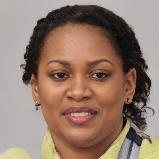 Joyful black adult female with short  brown hair and brown eyes