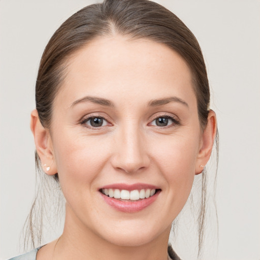 Joyful white young-adult female with medium  brown hair and grey eyes