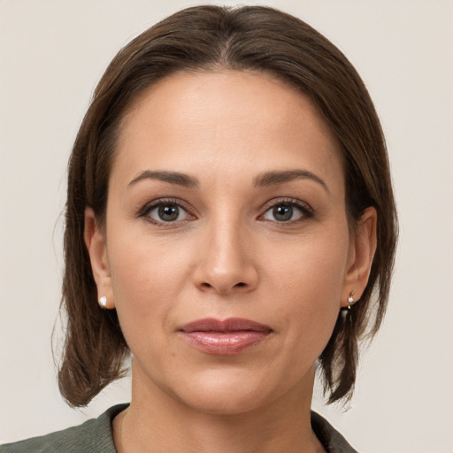 Joyful white young-adult female with medium  brown hair and grey eyes