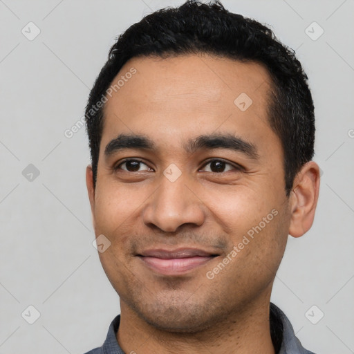 Joyful latino young-adult male with short  black hair and brown eyes