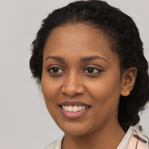 Joyful black young-adult female with medium  brown hair and brown eyes