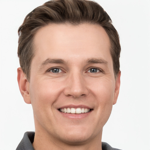 Joyful white young-adult male with short  brown hair and grey eyes