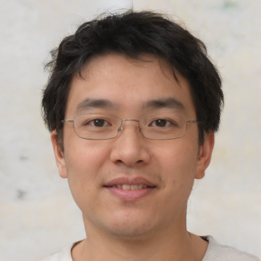 Joyful asian young-adult male with short  brown hair and brown eyes