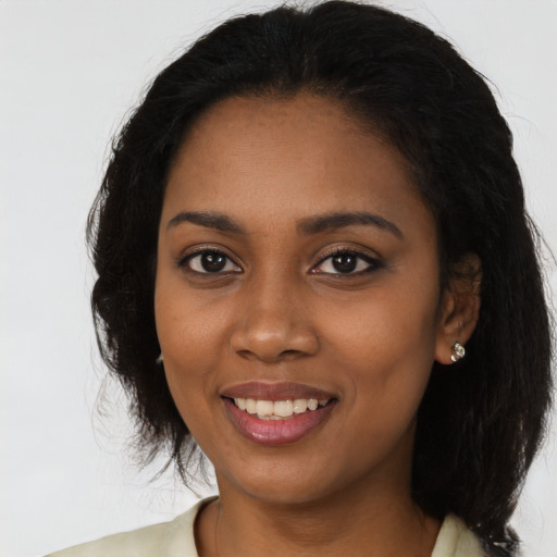 Joyful black young-adult female with long  black hair and brown eyes