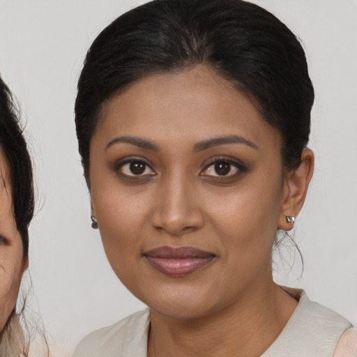 Joyful black young-adult female with medium  brown hair and brown eyes