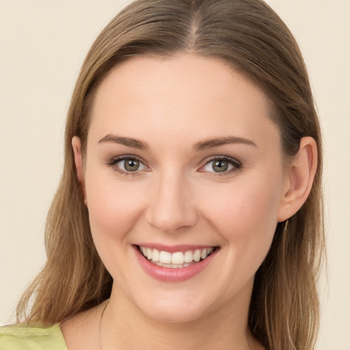 Joyful white young-adult female with long  brown hair and green eyes