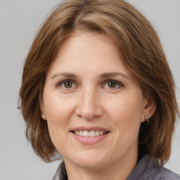 Joyful white adult female with medium  brown hair and grey eyes