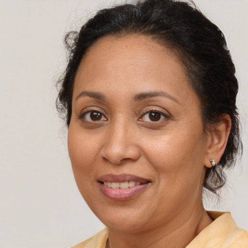 Joyful latino adult female with medium  brown hair and brown eyes