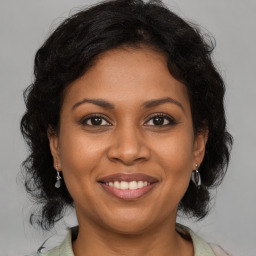 Joyful black adult female with medium  brown hair and brown eyes