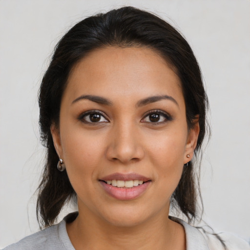 Joyful latino young-adult female with medium  brown hair and brown eyes