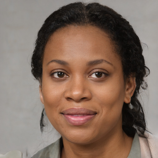 Joyful black adult female with medium  brown hair and brown eyes