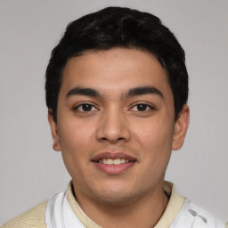 Joyful latino young-adult male with short  black hair and brown eyes