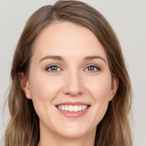 Joyful white young-adult female with long  brown hair and green eyes