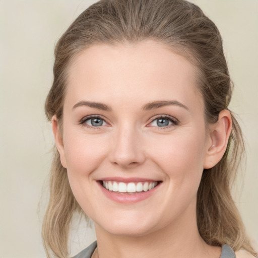 Joyful white young-adult female with medium  brown hair and grey eyes