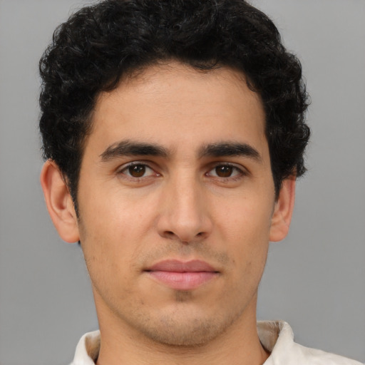 Joyful latino young-adult male with short  brown hair and brown eyes