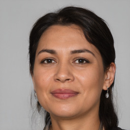 Joyful latino adult female with medium  brown hair and brown eyes