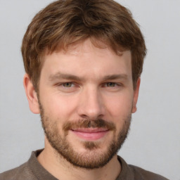 Joyful white young-adult male with short  brown hair and grey eyes