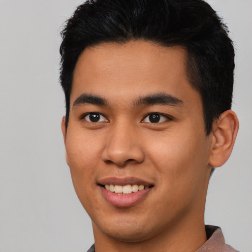 Joyful asian young-adult male with short  black hair and brown eyes