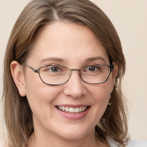 Joyful white adult female with long  brown hair and grey eyes