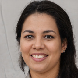 Joyful latino young-adult female with long  brown hair and brown eyes