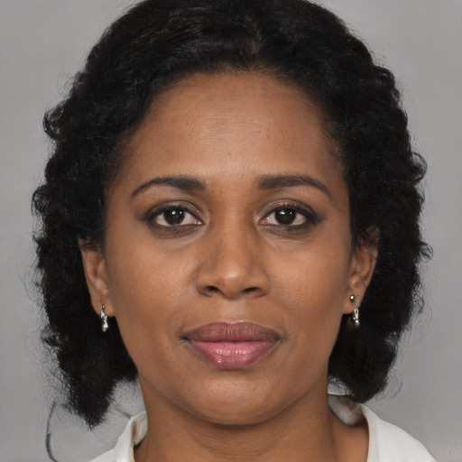 Joyful black adult female with medium  brown hair and brown eyes